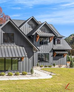 this is an image of a house in the country side with gray siding and wood accents