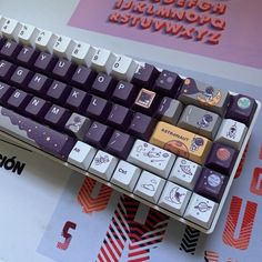 a purple and white keyboard sitting on top of a table