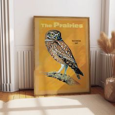 an owl sitting on top of a tree branch in front of a yellow poster that says the prairies