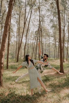 an engaged couple dancing in the woods