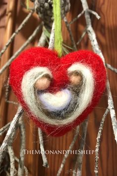 a red felt heart hanging from a tree