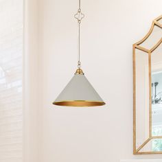 a white sink sitting under a bathroom mirror next to a gold framed wall mounted light