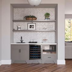 a wine cooler in the middle of a room with shelves and cabinets on either side