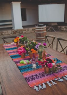 a table with flowers and candles on it for a mexican themed wedding in san diego, california