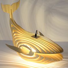 a lamp that looks like a boat with a whale tail on it's side