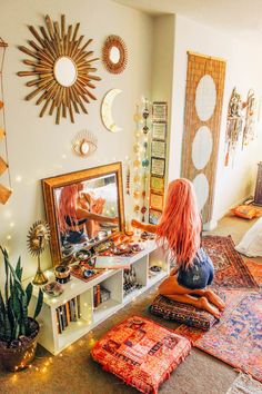 a woman sitting on the floor in front of a mirror