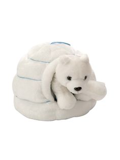 a stuffed polar bear laying on top of a pile of blankets