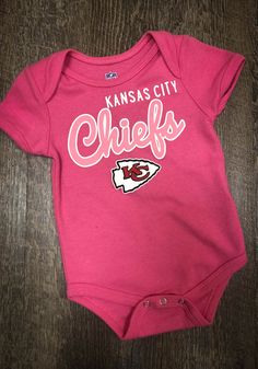 Kansas City Chiefs Baby Pink Big Game Short Sleeve One Piece Casual Onesie With Letter Print For Game Day, Sporty Onesie With Letter Print For Sports, Casual Sports Onesie With Letter Print, Casual Cotton Onesie For Sports Events, Fitted Letter Print Top For Playwear, Fitted Tops With Letter Print For Playwear, Sports Cotton Onesie With Short Sleeves, Cotton Onesie With Letter Print For Sports Events, Casual Sports Onesie With Short Sleeves