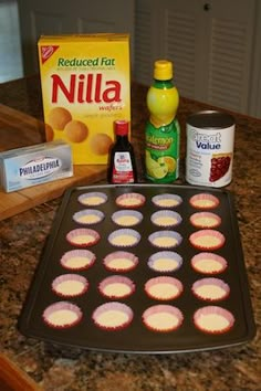 cupcakes and other ingredients on a counter top with a muffin tin in the foreground