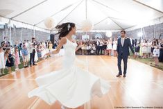 a bride and groom are dancing on the dance floor in front of an audience at a wedding