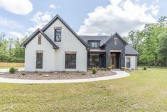 This New American house plan has a painted brick facade and a covered front porch entry. Three gables and a shed dormer help give it great curb appeal. The grand entrance front porch and the painted brick facade are just a few of the details that set this home apart. Volume ceilings throughout the main living areas create impressive spaces, and the gourmet kitchen with walk-in pantry is every home cook's dream while the covered outdoor kitchen provides additional space for entertaining.  Th White And Black Brick House Exterior, White Brick With Stone Exterior, All Brick House, White Brick House Exterior, Three Gables, Brick And Siding Exterior, Painted Brick Exterior, White Brick House, Brick Exteriors