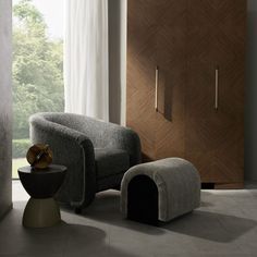 a grey chair and ottoman in front of a wooden cabinet