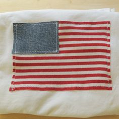 an american flag made out of old jeans on top of a white cloth with red and blue stripes