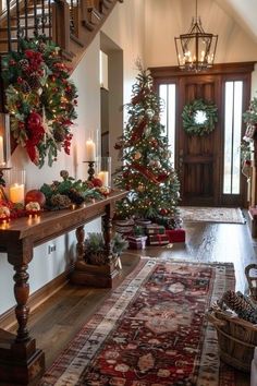 christmas decorations and candles are on display in the entryway to a house with stairs