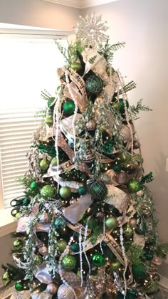 a christmas tree decorated with green and silver ornaments