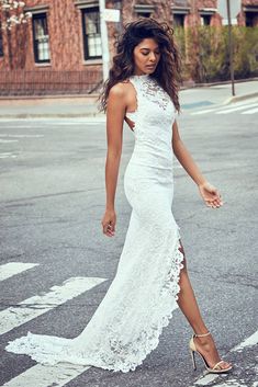 a woman in a white dress crossing the street