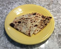 two pieces of flat bread on a yellow plate