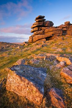 some rocks and grass on the side of a hill