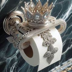 a crown on top of a roll of toilet paper with jewels and pearls around it