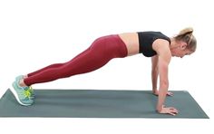 a woman doing push ups on a yoga mat