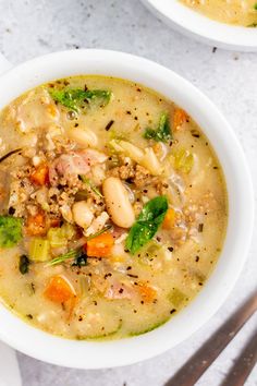 two white bowls filled with soup on top of a table