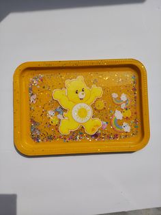 there is a yellow tray with a bear on it