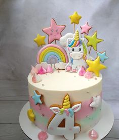 a birthday cake decorated with unicorns and stars