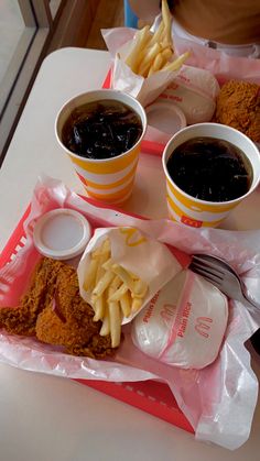 two trays filled with different types of food on top of a white table next to each other