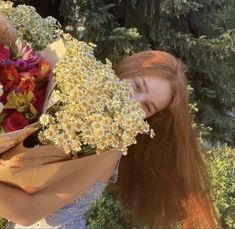 a woman is holding flowers in her hands