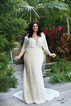 a woman in a white dress standing on a wooden deck