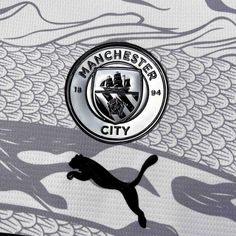 the manchester city logo is shown on top of a wallpaper with a cat running in front of it