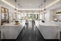 a large kitchen with marble counter tops and white cabinets