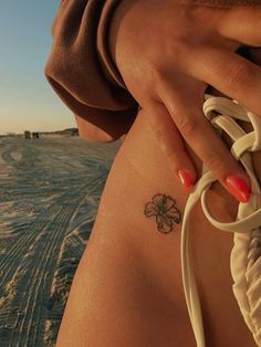 a woman's arm with a flower tattoo on it and a string attached to the side