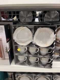 there are many plates and cups on the shelf