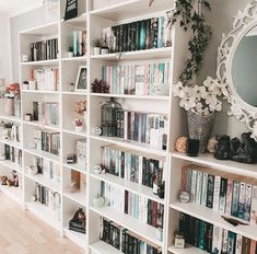 a bookshelf filled with lots of books next to a mirror