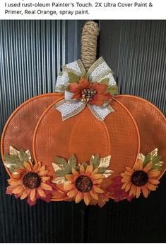 an orange pumpkin decorated with sunflowers and burlocks hanging on a door