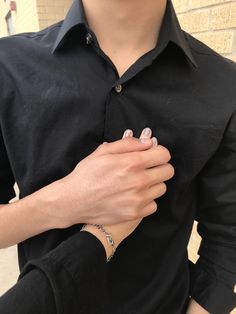 a man wearing a black shirt holding his hands together