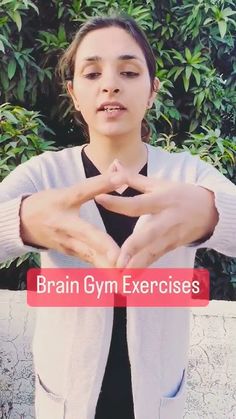 a woman making a heart shape with her hands and the words brain gym exercises in front of her