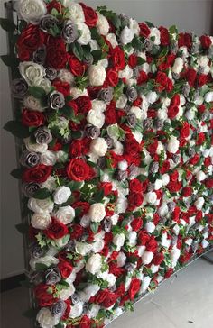 the wall is covered with red and white flowers, which are arranged in rows on top of each other