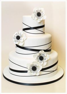 a white and black wedding cake with flowers on top