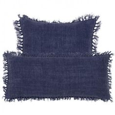 two dark blue pillows with fray edges