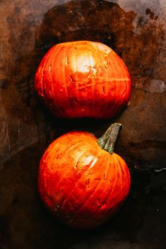 two orange pumpkins sitting on top of a table