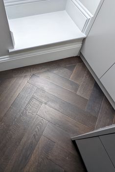 an empty kitchen with wood flooring and white cabinets