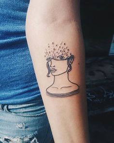 a woman's arm with a tattoo on it that has a drawing of a head