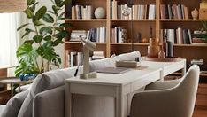 a living room filled with lots of furniture and bookshelves covered in shelves full of books