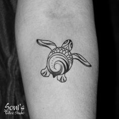 a small turtle tattoo on the arm