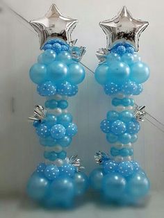 two blue and white balloons with silver stars on them are sitting in front of a wall