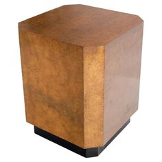 a square wooden box sitting on top of a white floor next to a black base