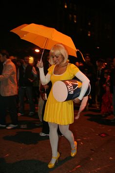 a woman in yellow dress holding an umbrella