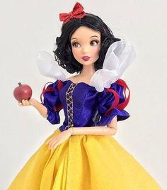 snow white doll holding an apple in her hand